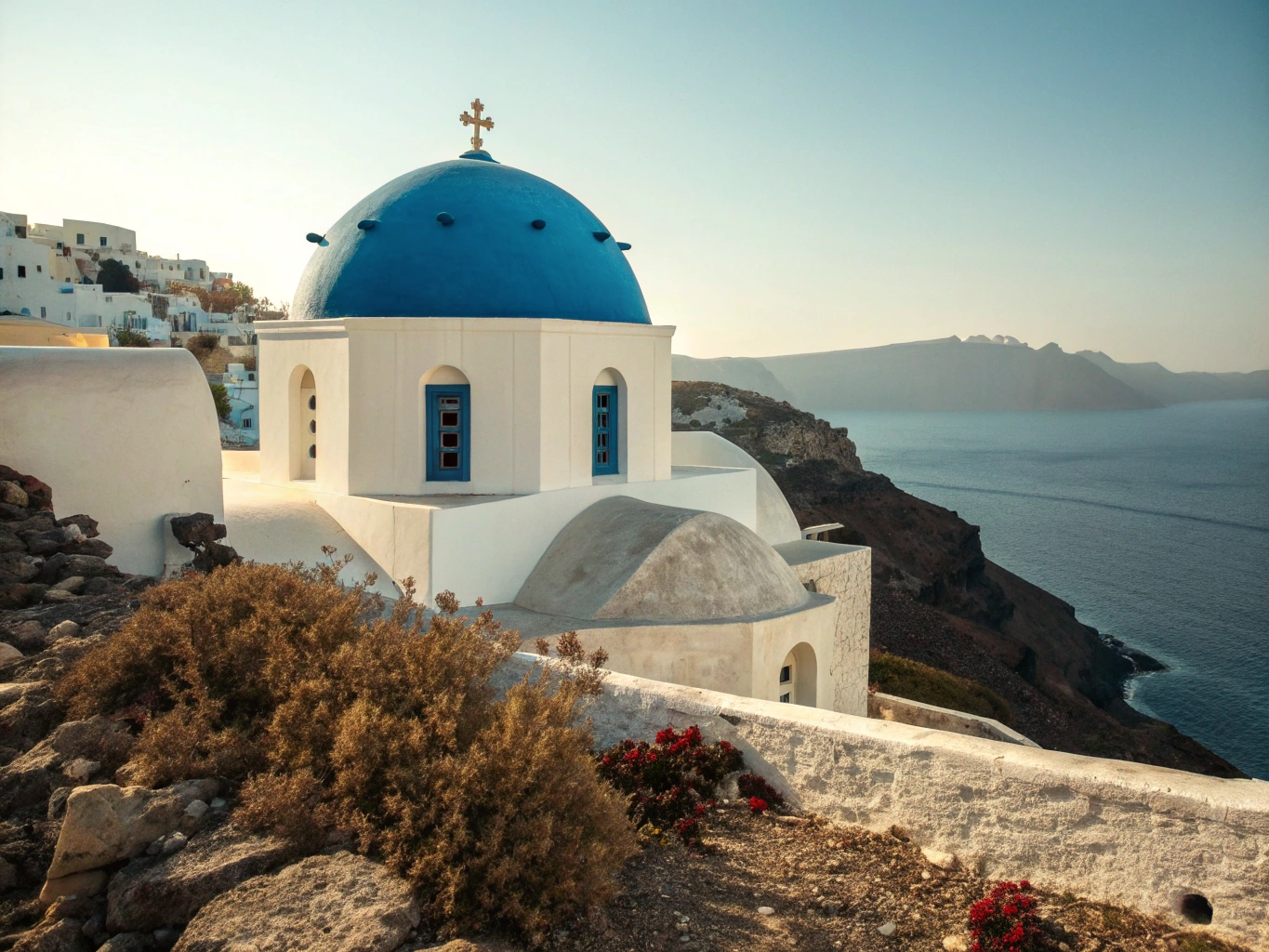 Iconic whitewashed Greek belfry with bougainvillea in foreground